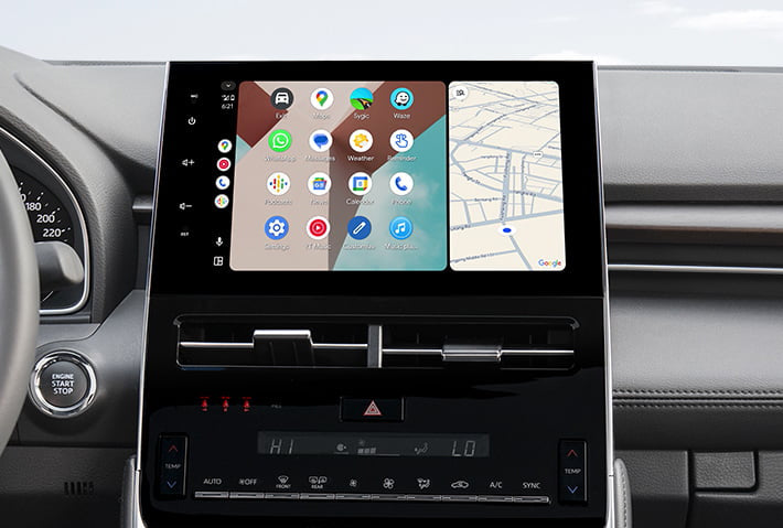 In-car view showing the Android Auto interface on a Toyota Sienna head unit, featuring a multi-pane layout with navigation and communication apps, compatible with both wired and wireless connections.